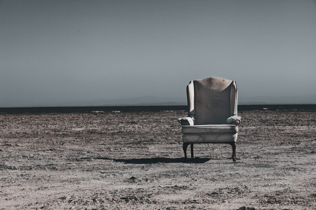 brown wooden armchair on brown sand during daytime